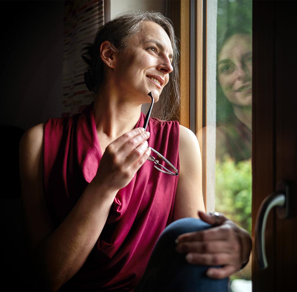 Die strategische Designerin Marion Bauer blickt nachdenklich aus dem Fenster, reflektiert dabei die Situation Ihres Kunden und entwickelt daraus eine klare Marketingstrategie.